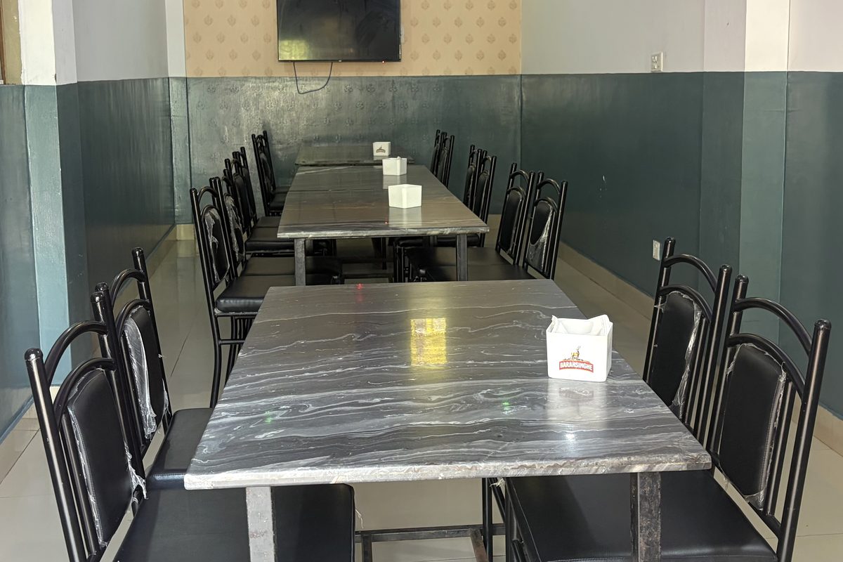The dining area at Api Hotel with marble-top tables and black chairs