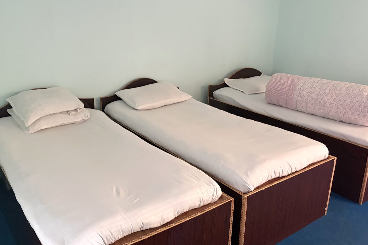 A guest room at Api Hotel with three single beds and fresh sheets