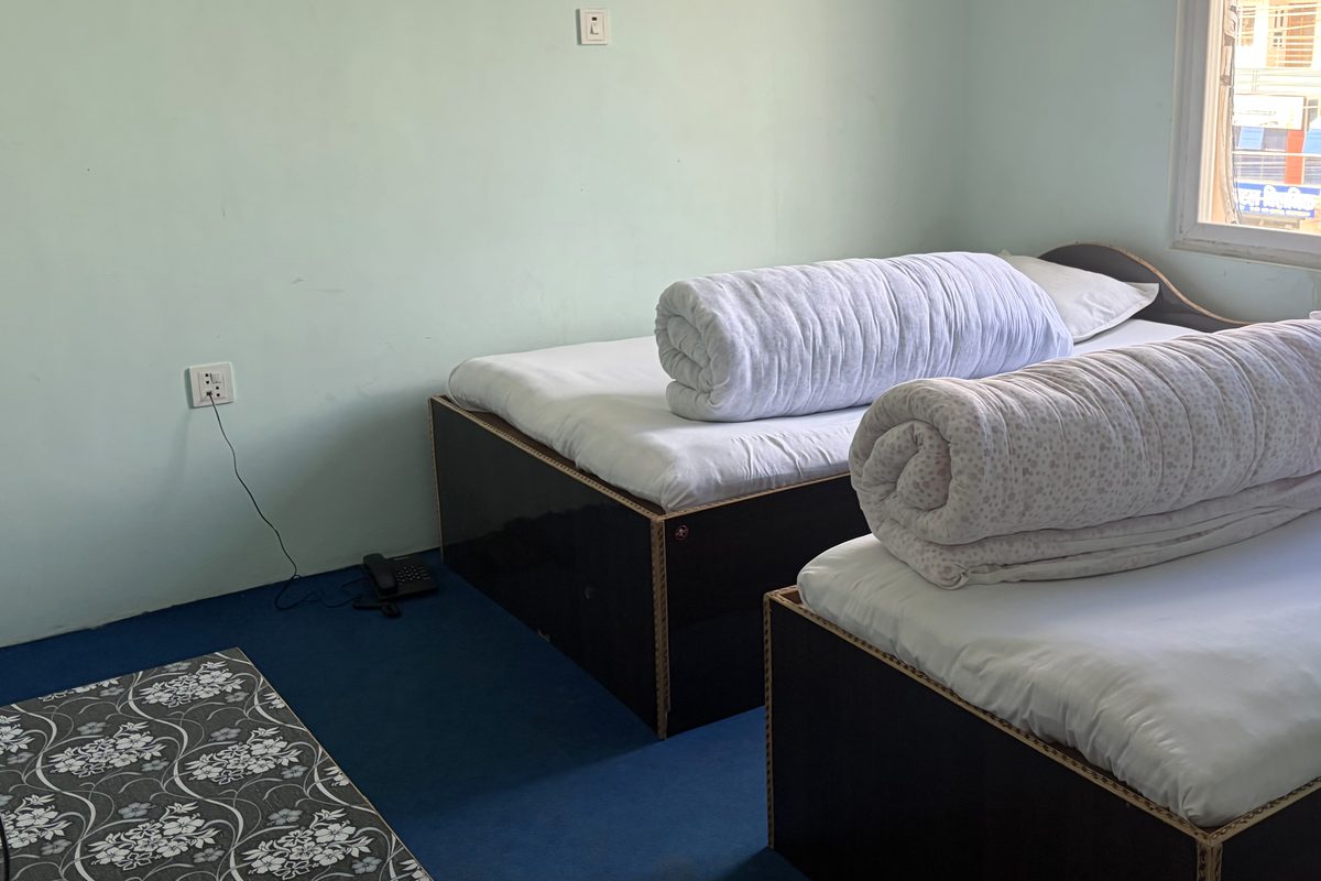 A bright guest room at Api Hotel with two beds and a window